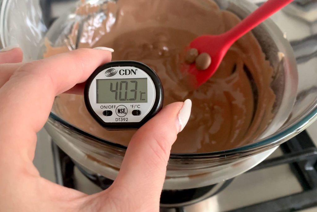 Digital thermometer being used to temper chocolate