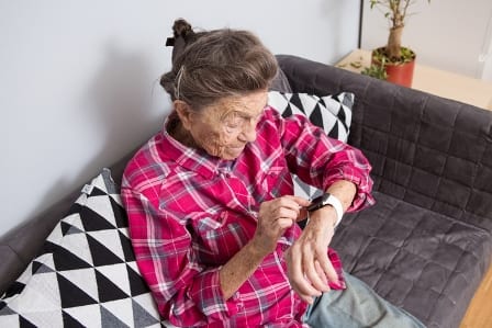 elderly lady looking at her smart watch