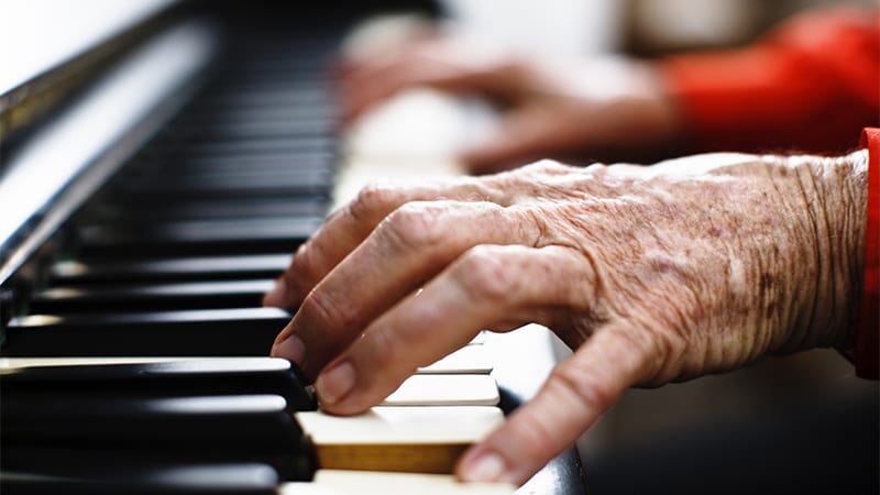 An elderly person playing the piano